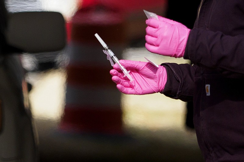 Staff photo by C.B. Schmelter / University of Tennessee at Chattanooga nursing student Lauren Buffington carries a dose of the COVID-19 vaccine near the Hubert Fry Center at the Tennessee Riverpark on Wednesday, Dec. 30, 2020 in Chattanooga, Tenn.