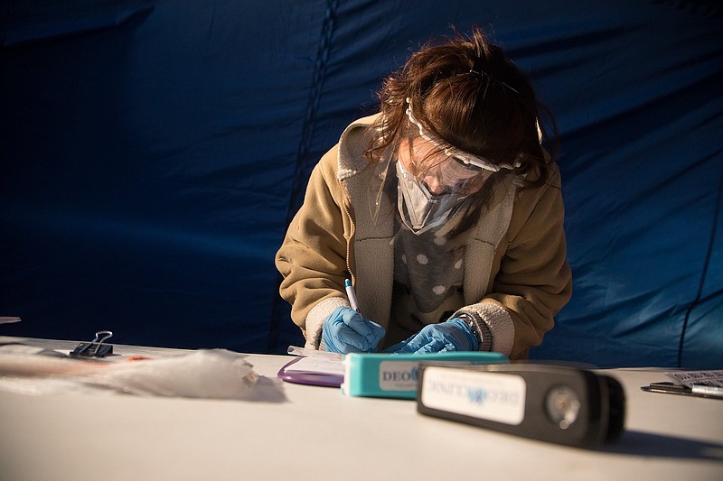 Staff photo by Troy Stolt / DEO clinic employee Teresa Mendez fills out paperwork for a Whitfield county resident to be tested for COVID-19 during testing the clinic offers to test uninsured residents of Whitfield County on Monday, Dec. 14, 2020 in Dalton, Georgia.