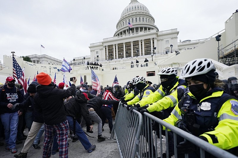 Trump supporters try to break through a police barrier, Wednesday, Jan. 6, 2021, at the Capitol in Washington. As Congress prepares to affirm President-elect Joe Biden's victory, thousands of people have gathered to show their support for President Donald Trump and his claims of election fraud. (AP Photo/Julio Cortez)