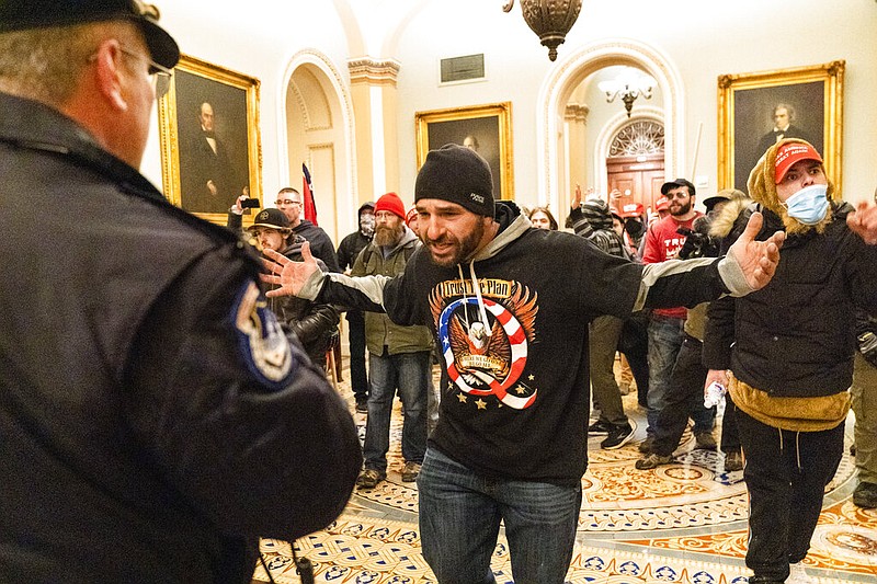 Supporters of President Donald Trump are confronted by Capitol Police officers outside the Senate Chamber at the Capitol, Wednesday, Jan. 6, 2021 in Washington. (AP Photo/Manuel Balce Ceneta)