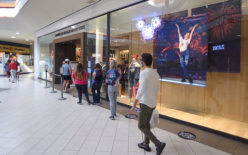 Staff File Photo by Matt Hamilton / American Eagle Outfitters shoppers wait in a line in front of the clothing store at Hamilton Place mall last November before Thanksgiving.