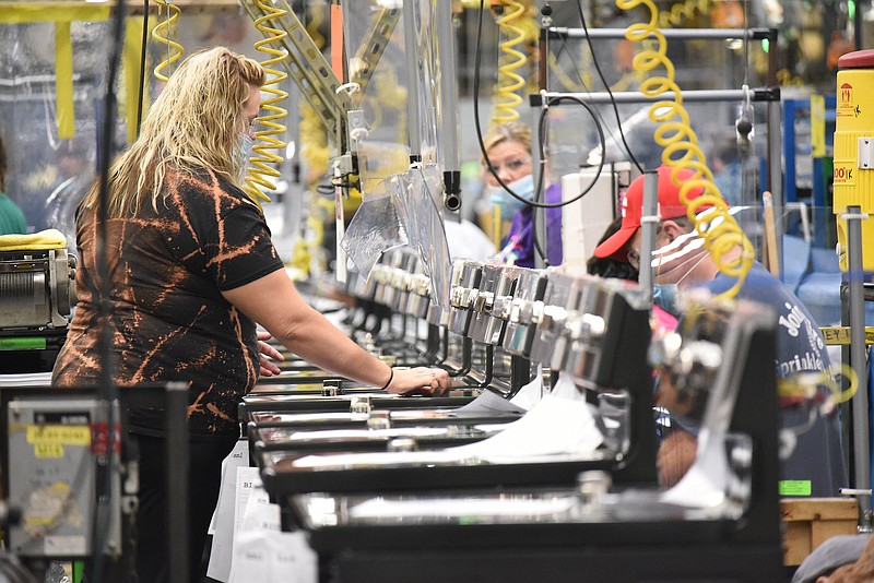 Staff Photo by Matt Hamilton / Workers build stoves on the assembly line at the GE Appliances Roper factory last October.