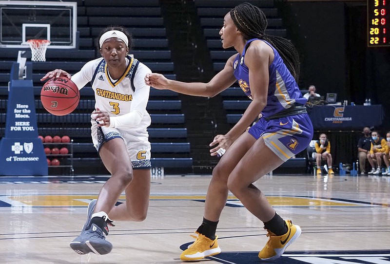 Staff photo by C.B. Schmelter / University of Tennessee at Chattanooga forward Eboni Williams (3) drives against Tennessee Tech guard Maaliya Owens (11) at McKenzie Arena on Friday, Dec. 11, 2020 in Chattanooga, Tenn.