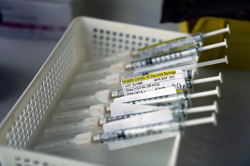 In this Jan. 7, 2021, file photo syringes containing the Pfizer-BioNTech COVID-19 vaccine sit in a tray in a vaccination room at St. Joseph Hospital in Orange, Calif. Taking a new direction to speed release of coronavirus vaccines, President-elect Joe Biden's office said Friday he would end the current practice of holding back vaccine doses to guarantee that people who get their first shot can also get a required second inoculation three weeks later. (AP Photo/Jae C. Hong, File)