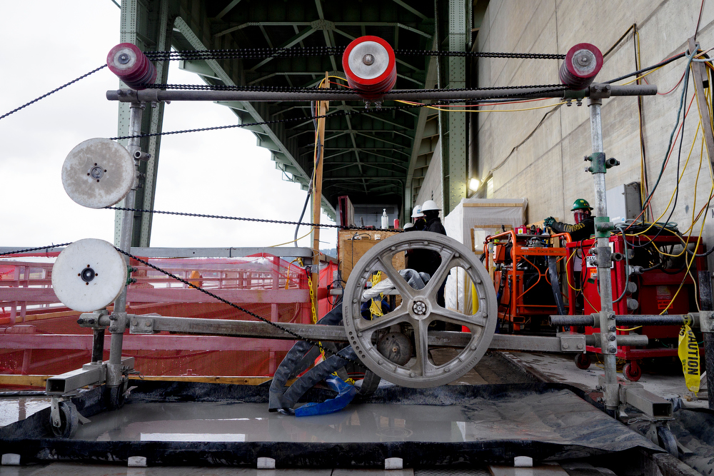 Staff photo by C.B. Schmelter / A steel cable with 15-millimeter diamond beads run through a series of pulleys atop the Chickamauga Dam on Friday, Jan. 8, 2021 in Chattanooga, Tenn. The cable is part of a diamond wire saw used to cut through the dam to allow for expansion of the concrete.