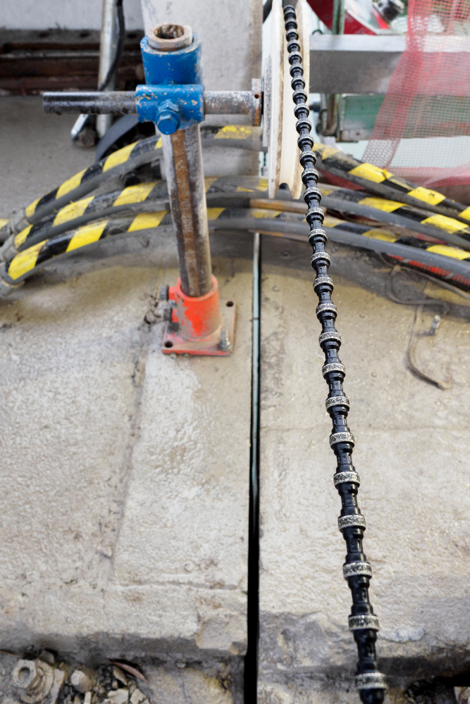 Staff photo by C.B. Schmelter / A steel cable with 15-millimeter diamond beads, and the cut made by the cable, are seen atop the Chickamauga Dam on Friday, Jan. 8, 2021 in Chattanooga, Tenn. The cable is part of a diamond wire saw used to cut through the dam to allow for expansion of the concrete.