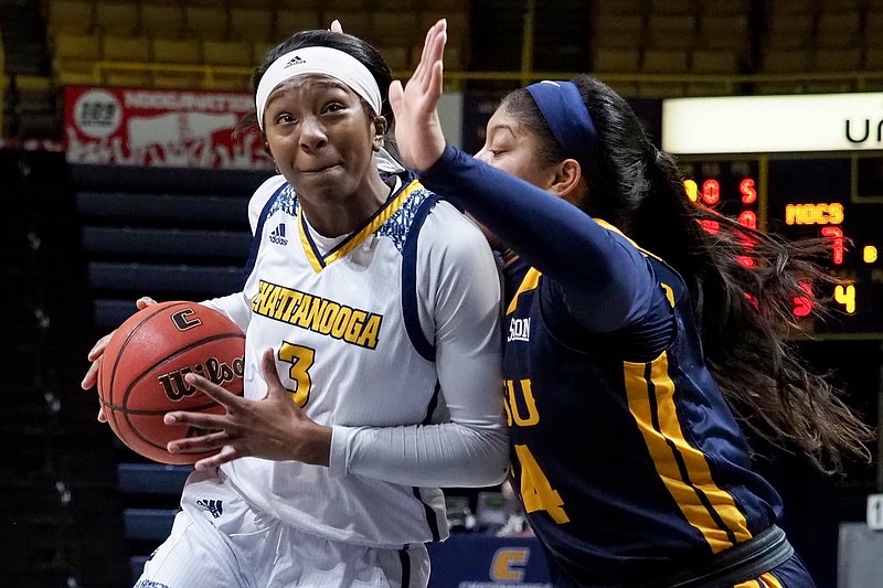 Staff photo by C.B. Schmelter / UTC junior forward Eboni Williams drives past East Tennessee State's Mykia Dowdell during the SoCon opener for both teams Saturday at McKenzie Arena. Williams had 18 points and 15 rebounds to help lead the Mocs to a 66-51 victory.