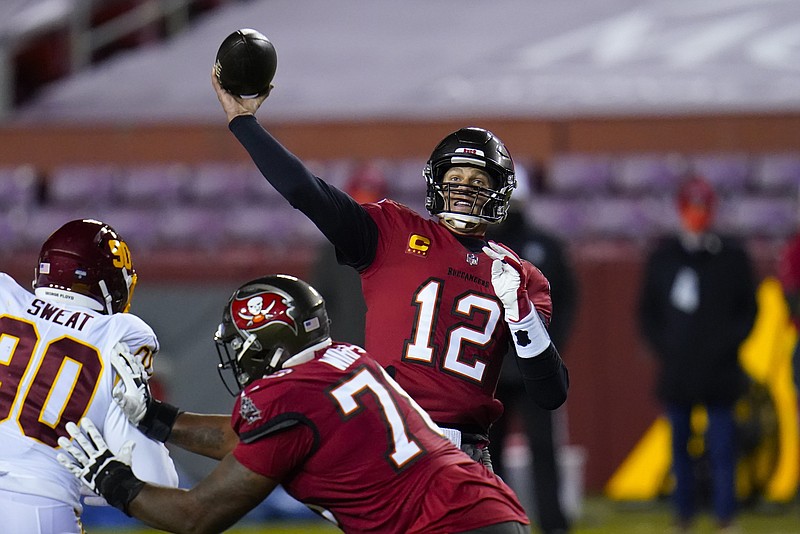 AP photo by Julio Cortez / Tampa Bay Buccaneers quarterback Tom Brady throws a touchdown pass to wide receiver Antonio Brown, not pictured, during the first half of Saturday night's game in Landover, Md.