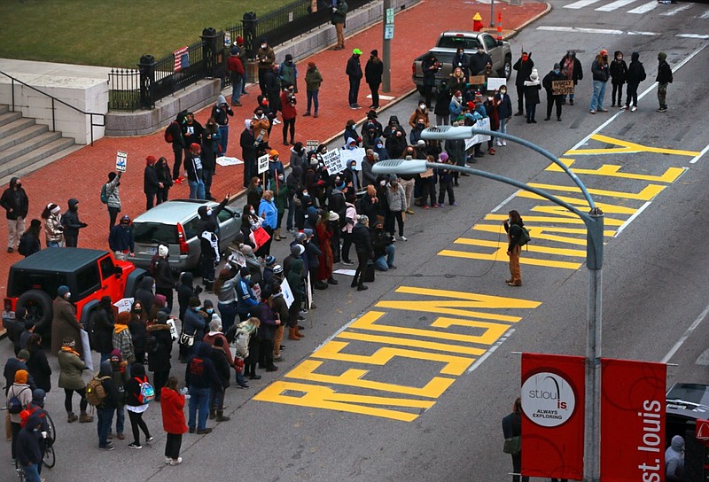 About 300 demonstrators gather after painting a sign in the middle of Broadway Saturday, Jan. 9, 2021 outside the historic Old Courthouse in downtown St. Louis. Speakers called for Sen. Josh Hawley, R-Mo., to resign following a seizure and occupation of the U.S. Capitol in Washington. (Christian Gooden/St. Louis Post-Dispatch via AP)