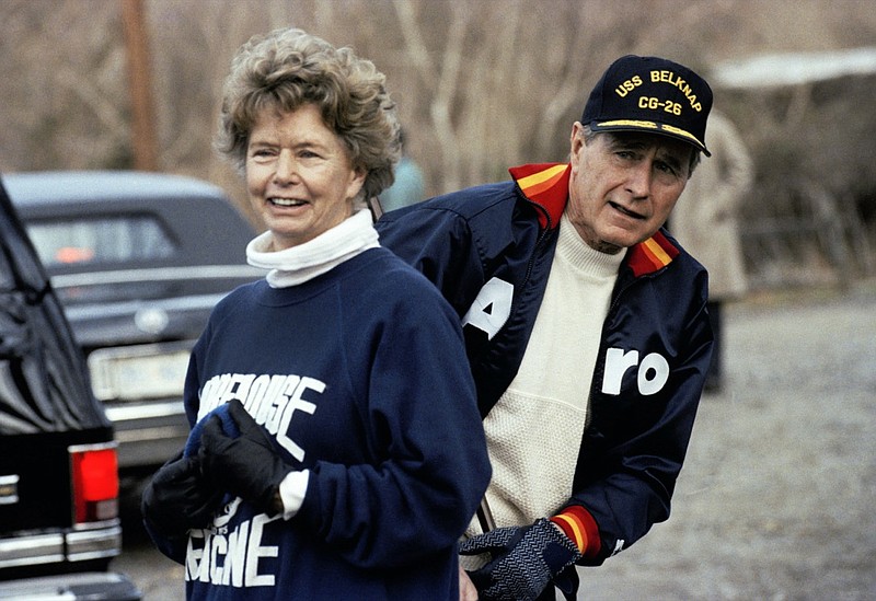 FILE — This Jan. 7, 1990, file photo shows President George H. W. Bush hiding behind his sister, Nancy Ellis, as he prepares for a jog along the C&O canal in the Georgetown section of Washington. A longtime Democrat who helped her Republican brother and nephew get elected president, died of complications of the coronavirus Sunday, Jan. 10, 2021, at an assisted living facility in Concord, Massachusetts. She was 94. (AP Photo/Marcy Nighswander, File)

