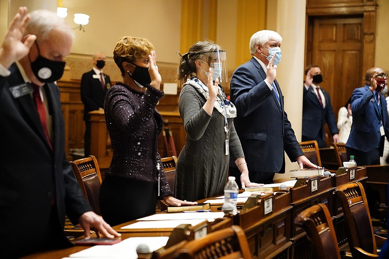 State Senators, from left, Lindsey Tippins, Sonya Halpern, Sally Harrell, and Bill Cowsert are sworn in during the opening day of the legislative sessions on Monday, Jan. 11, 2021, in Atlanta. (AP Photo/Brynn Anderson)