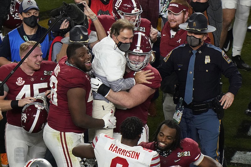 Players celebrate with Alabama head coach Nick Saban after their win against Ohio State in an NCAA College Football Playoff national championship game, Monday, Jan. 11, 2021, in Miami Gardens, Fla. Alabama won 52-24. (AP Photo/Wilfredo Lee)