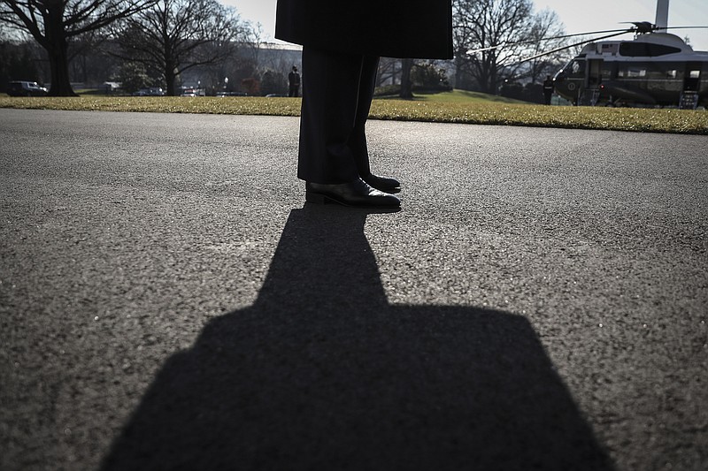 New York Times photo by Oliver Contreras/President Donald Trump casts a shadow as he talks to reporters at the White House on Tuesday before boarding Marine One for a trip to Alamo, Texas, his first public appearance in nearly a week after his supporters violently attacked the U.S. Capitol in an effort to overturn election results.
