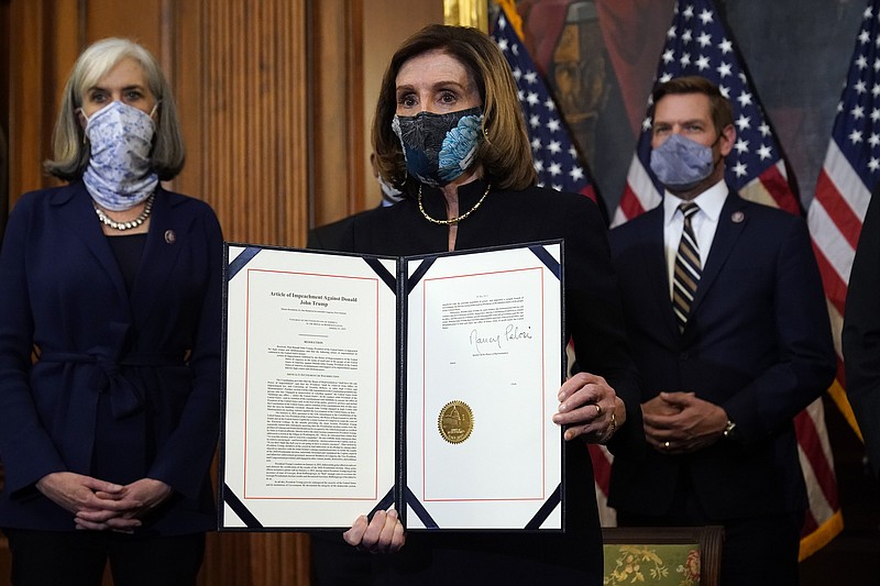 AP Photo by Alex Brandon/House Speaker Nancy Pelosi of California displays the signed article of impeachment against President Donald Trump on Capitol Hill on Wednesday.