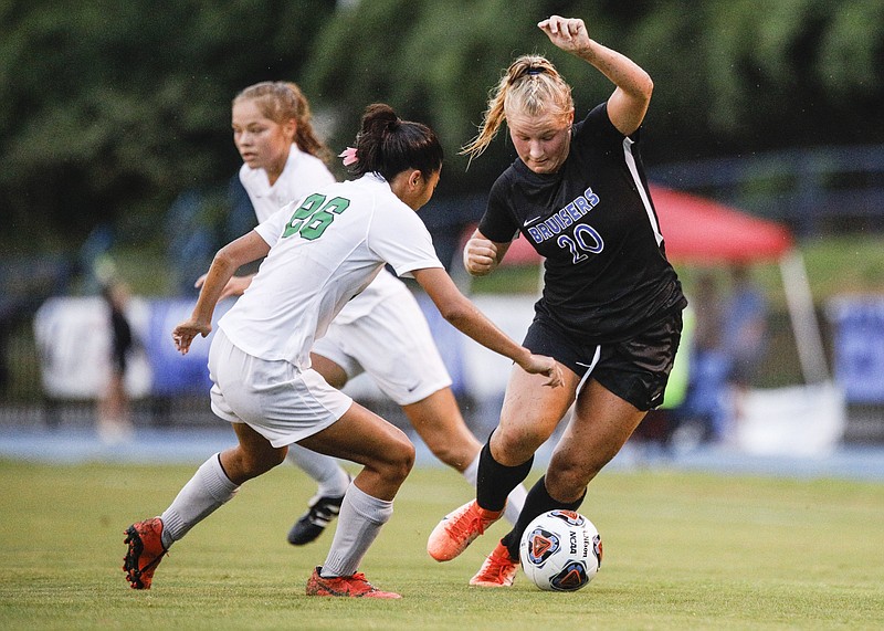 Staff photo by Troy Stolt / GPS soccer player Ashley Grant, right, dribbles past an East Hamilton defender during a match at GPS this past September.