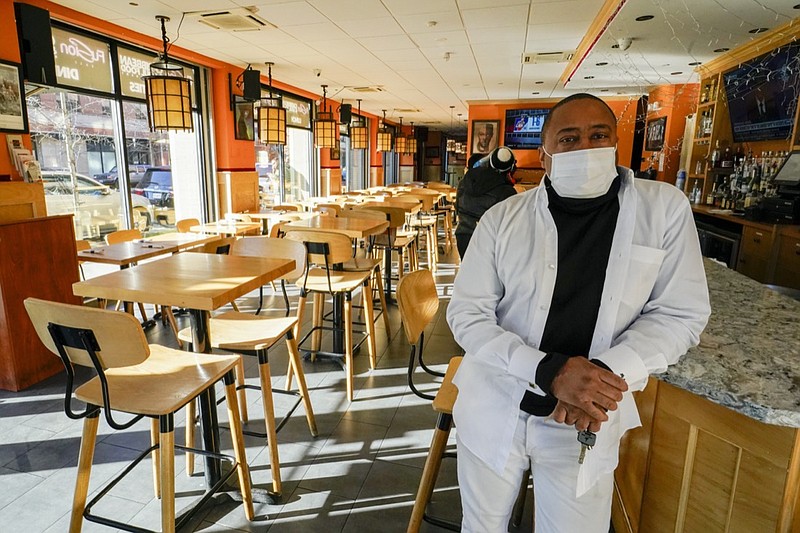 Andrew Walcott, owners of Fusion East Caribbean & Soul Food restaurant, poses for a photo at the restaurant in East New York neighborhood of the Brooklyn borough of New York, Thursday, Jan. 7, 2021. Walcott had to furlough four employees at his restaurant just before Christmas, after New York state stopped allowing indoor dining. (AP Photo/Mary Altaffer)