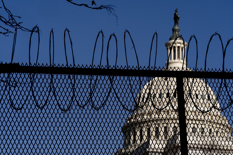 The Dome of the Capitol Building is visible through razor wire installed on top of fencing on Capitol Hill in Washington, Thursday, Jan. 14, 2021. (AP Photo/Andrew Harnik)