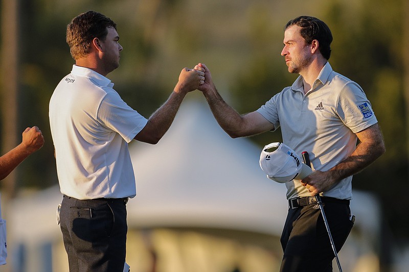 AP photo by Jamm Aquino / Nick Taylor, right, bumps fists with Keith Mitchell after they finished the second round of the PGA Tour's Sony Open on Friday at Waialae Country Club in Honolulu.