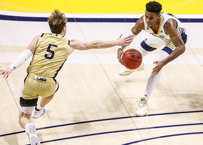 Staff photo by Troy Stolt / UTC guard Malachi Smith, right, dribbles into the paint against Wofford's Storm Murphy during Saturday's SoCon game at McKenzie Arena. Smith led UTC with 15 points, but Murphy scored a game-high 23 as the Terriers dominated during the second half to win 77-59.