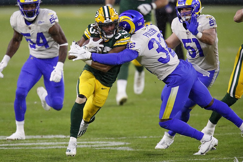 AP photo by Matt Ludtke / Green Bay Packers running back Aaron Jones is tackled by the Los Angeles Rams' Jordan Fuller during the first half of an NFC playoff game Saturday night in Green Bay, Wis.