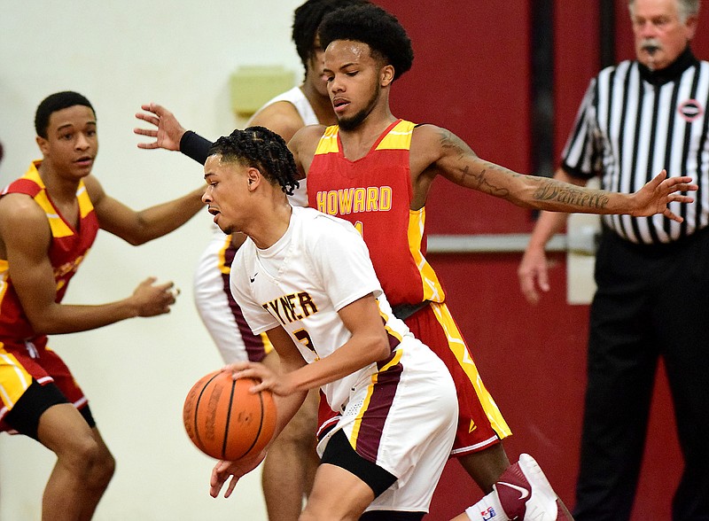 Staff photo by Robin Rudd / Tyner's Amarion Dillard (3) dribbles as Howard defends the perimeter during Saturday night's game at Tyner. Tyner won 55-39.