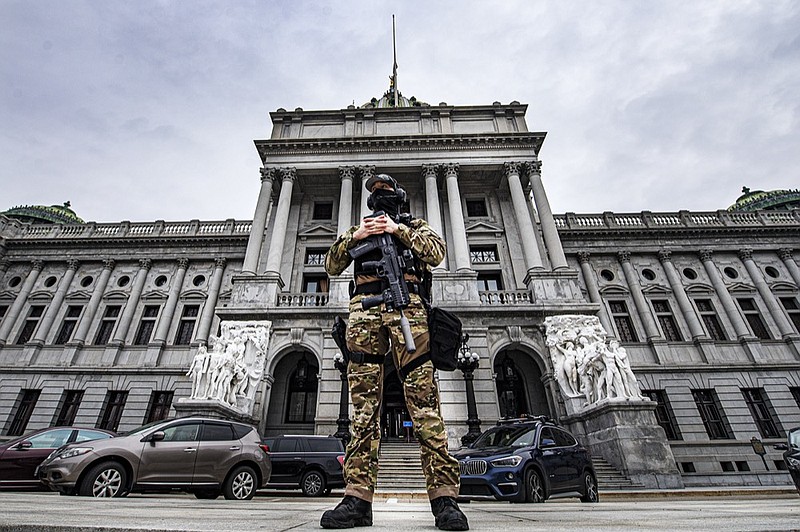 A member of the Pennsylvania Capitol Police stands guard at the entrance to the Pennsylvania Capitol Complex in Harrisburg, Pa., Wednesday, Jan. 13, 2021. State capitols across the country are under heightened security after the siege of the U.S. Capitol last week. (Jose F. Moreno/The Philadelphia Inquirer via AP)


