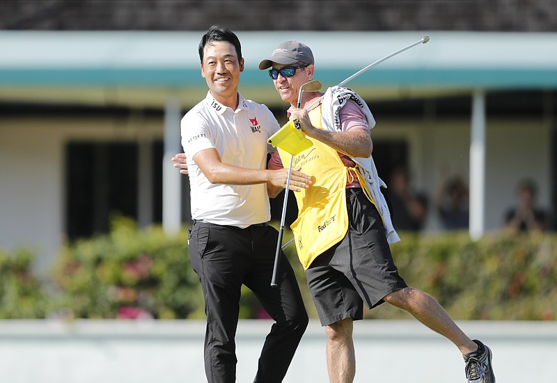 Honolulu Star-Advertiser photo by Jamm Aquino via AP / Kevin Na, left, embraces caddie Kenneth Harms after winning the PGA Tour's Sony Open on Sunday at Waialae Country Club in Honolulu.