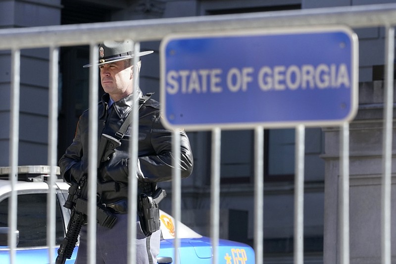 A Georgia State Patrol trooper stands guard outside the Georgia Capitol Friday, Jan. 15, 2021, in Atlanta. With the FBI warning of potential violence at all state capitols Sunday, Jan. 17, the ornate halls of government and symbols of democracy looked more like heavily guarded U.S. embassies in war-torn countries. (AP Photo/John Bazemore)