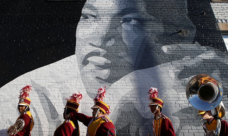Staff file photo by C.B. Schmelter / Members of the Howard School marching band walk past a mural of Martin Luther King Jr. while lining up for a memorial parade and march along M.L. King Boulevard on Jan. 15, 2018, in Chattanooga.