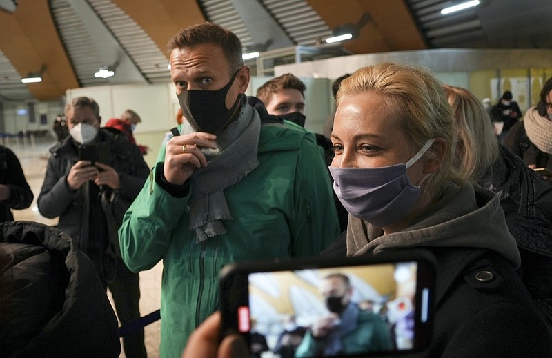 Alexei Navalny and his wife Yuliastand in line at the passport control after arriving at Sheremetyevo airport, outside Moscow, Russia, Sunday, Jan. 17, 2021. Russia's prison service says opposition leader Alexei Navalny has been detained at a Moscow airport after returning from Germany. (AP Photo/Mstyslav Chernov)
