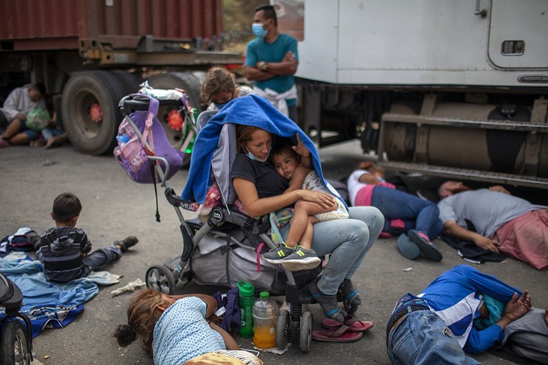 Honduran migrants gather in front of a police roadblock at a highway in Vado Hondo, Guatemala, Guatemala, Sunday, Jan. 17, 2021. Guatemalan police and soldiers launched tear gas and wielded batons and shields against a group of Honduran migrants that tried to push through their roadblock early Sunday. (AP Photo/Sandra Sebastian)