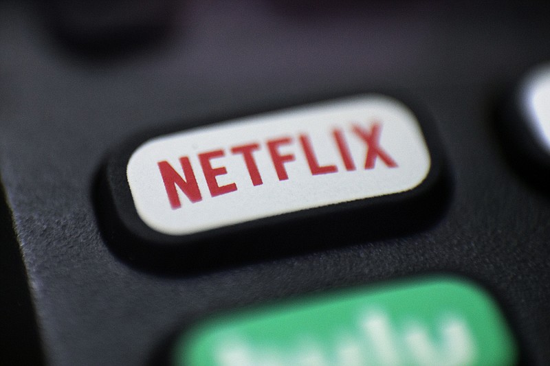 This Aug. 13, 2020, file photo shows a logo for Netflix on a remote control in Portland, Ore. Netflix's video streaming service has surpassed 200 million subscribers for the first time as its expanding line-up of TV series and movies continues to captivate people stuck at home during the ongoing battle against the pandemic. The subscriber milestone highlighted Netflix's fourth-quarter results released Tuesday, Jan. 19, 2021. (AP Photo/Jenny Kane, File)