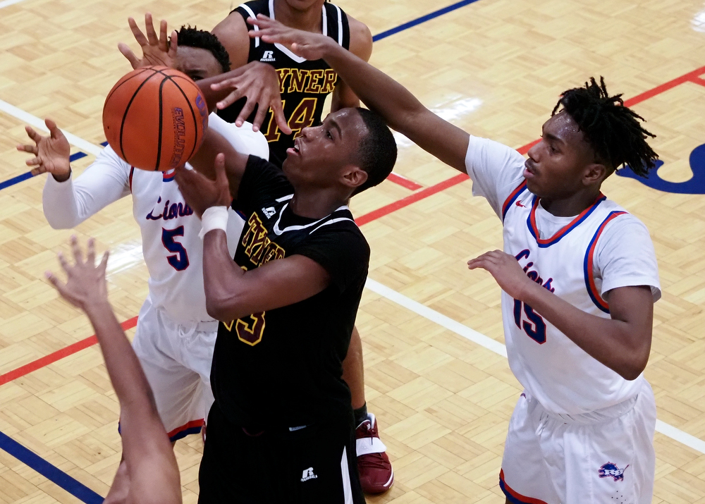 Staff photo by C.B. Schmelter / Tyner's Keelan Jackson (13) fights to get the ball up against Red Bank's Nick Smith (5) and Kendrick Loyd (15) at Susan Ingram Thurman Gymnasium on the campus of Red Bank High School on Thursday, Jan. 21, 2021 in Chattanooga, Tenn.