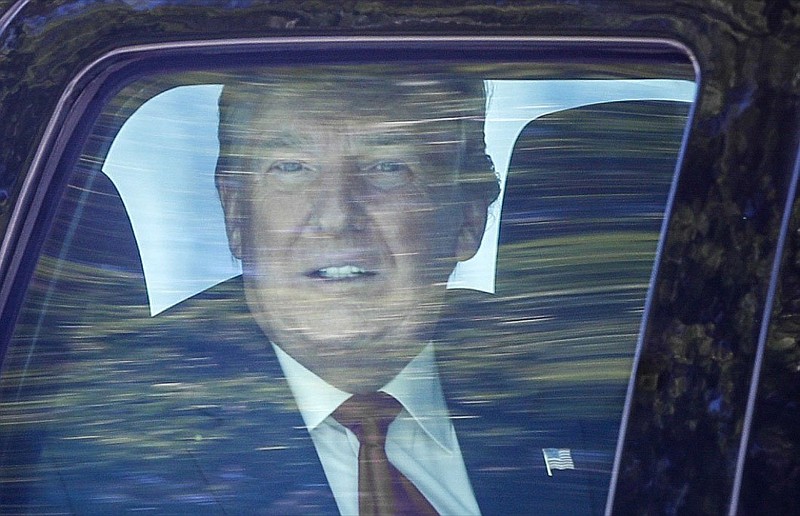 Former President Donald Trump looks out his window as his motorcade drives through West Palm Beach, Fla., on his way to his Mar-a-Lago club in Palm Beach after arriving from Washington aboard Air Force One on Wednesday, Jan. 20, 2021. (Damon Higgins/The Palm Beach Post via AP)