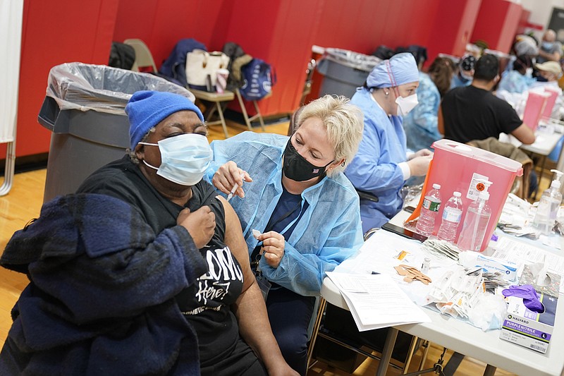 Mary Jenkins, left, received the COVID-19 vaccine in Paterson, N.J., Thursday, Jan. 21, 2021. The first people arrived around 2:30 a.m. for the chance to be vaccinated at one of the few sites that does not require an appointment. Smaller-than-expected vaccine deliveries from the federal government have caused frustration and confusion and limited states' ability to attack the outbreak that has killed over 400,000 Americans. (AP Photo/Seth Wenig)