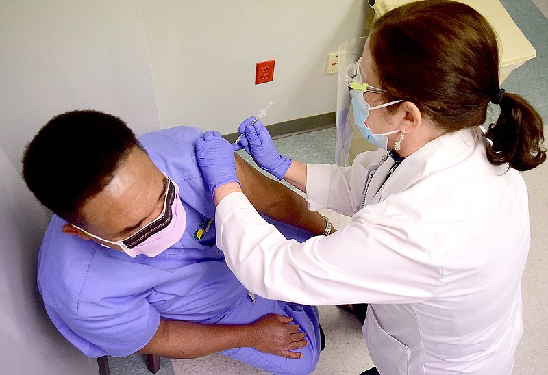 Staff Photo by Robin Rudd / Deborah Deal, RN, Chief Nursing Executive gives Dr. Winfred Manta, Intensive Care Physician a vaccination. 