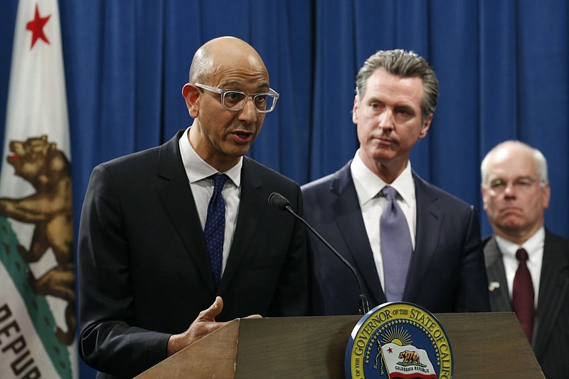 FILE - In this March 12, 2020, file photo Dr. Mark Ghaly, secretary of the California Health and Human Services, discusses the coronavirus as Gov. Gavin Newsom, center, listens at a news conference in Sacramento, Calif. Sacramento area officials were caught off guard when the state public health agency lifted the regional stay-at-home order, allowing businesses like barber and beauty shops and nail salons, to reopen, restaurants to offer outdoor dining, and houses of worship to offer outdoor services. (AP Photo/Rich Pedroncelli, File)


