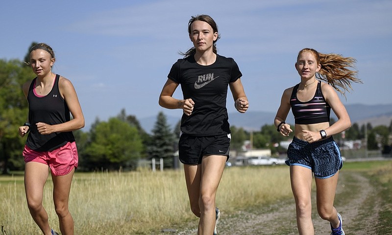 FILE - In this Aug. 15, 2019, file photo, is University of Montana cross country runner Juniper Eastwood, center, warming up with her teammates at Campbell Park in Missoula, Mont. Transgender kids would be banned from playing on school sports teams for the gender with which they identify under a GOP-backed bill that advanced Thursday, Jan. 21, 2021, in Montana. The proposed ban is personal for people like Eastwood, a transgender woman and former member of the University of Montana's track and field and cross-country running teams. She said the legislation "would make it impossible for other young Montanans like me to participate in sports as who they are." (Rachel Leathe/Bozeman Daily Chronicle via AP, file)


