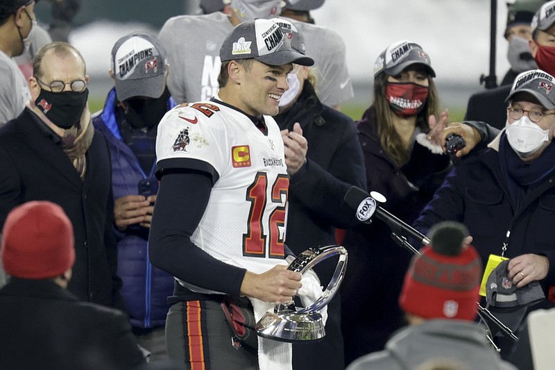 Tampa Bay Buccaneers quarterback Tom Brady (12) holds the championship trophy after winning the NFC championship NFL football game against the Green Bay Packers in Green Bay, Wis., Sunday, Jan. 24, 2021. The Buccaneers defeated the Packers 31-26 to advance to the Super Bowl. (AP Photo/Matt Ludtke)