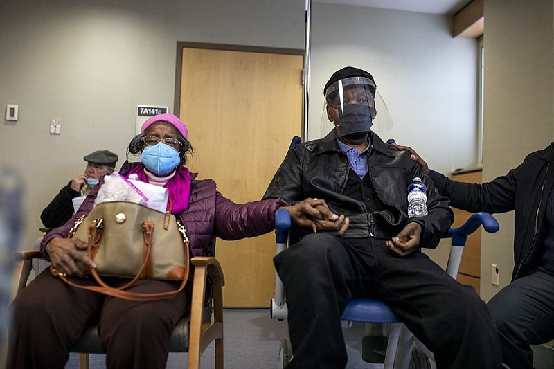 FILE - In this Jan. 23, 2021, file photo, Dorothy Kade, left, holds the hand of her husband, Walter Kade Jr., as they wait in the observation room after he received a COVID-19 vaccine at the VA Medical Center, in Philadelphia. (Tyger Williams/The Philadelphia Inquirer via AP, File)