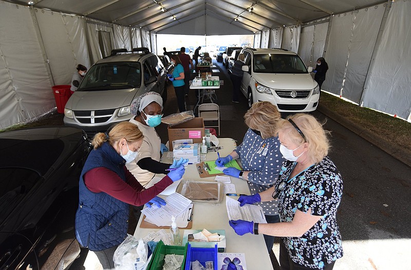 Staff Photo by Matt Hamilton /   A group of nurses prepares and administers doses of the Pfizer COVID-19 vaccine at the vaccination site at the Tennessee Riverpark on Tuesday, Jan. 26, 2021. 