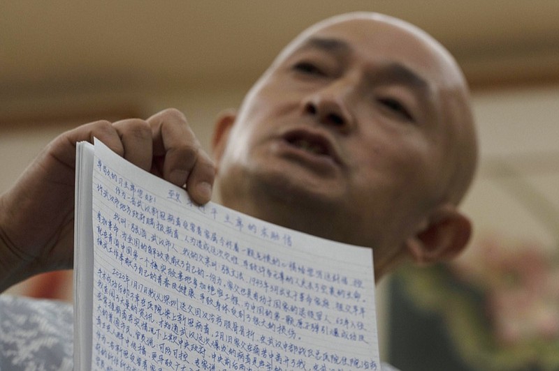 Zhang Hai holds up an open letter he wrote to the Chinese President Xi Jinping during an interview in Shenzhen in southern China's Guangdong province on Friday, Oct. 16, 2020. Zhang is demanding to meet a visiting World Health Organization expert team, saying it should speak with affected families who allege they are being muffled by the Chinese government.(AP Photo/Ng Han Guan)


