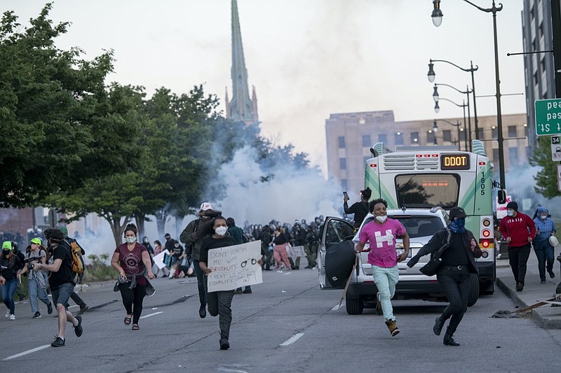 FILE - In this May 31, 2020 file photo, Detroit police fire tear gas at protesters during the third day of protesting police brutality and justice for George Floyd in Detroit. The city of Detroit said Tuesday, Jan. 26, 2021, it will dismiss most misdemeanor citations issued last spring during several days of protests against police brutality following the death of Floyd in Minneapolis. Most of the tickets written May 31 and June 2, were for curfew violations as hundreds of people demonstrated in downtown Detroit. (Nicole Hester/Ann Arbor News via AP, File)

