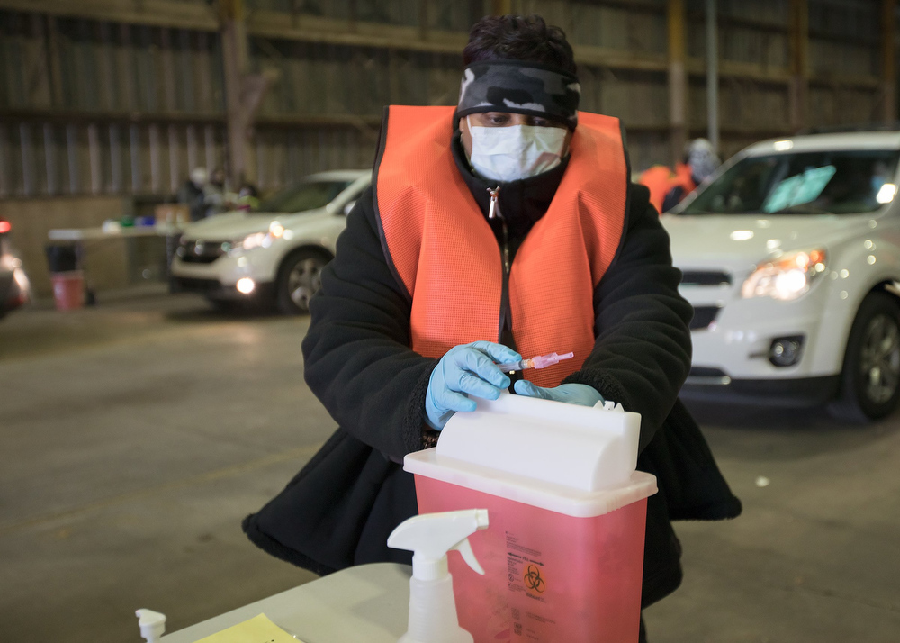 Staff photo by Troy Stolt / LPN Adrian Price disposes of a used syringe after administering a dose of the Moderna COVID-19 vaccine at the Hamilton County Health Department's new COVID Vaccination POD at the CARTA Bus Terminal on Thursday, Jan. 28, 2021 in Chattanooga, Tenn.