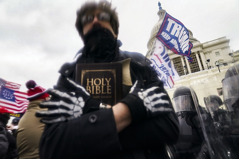 FILE - In this Wednesday, Jan. 6, 2021 file photo, a man holds a Bible as Trump supporters gather outside the Capitol in Washington. (AP Photo/John Minchillo)


