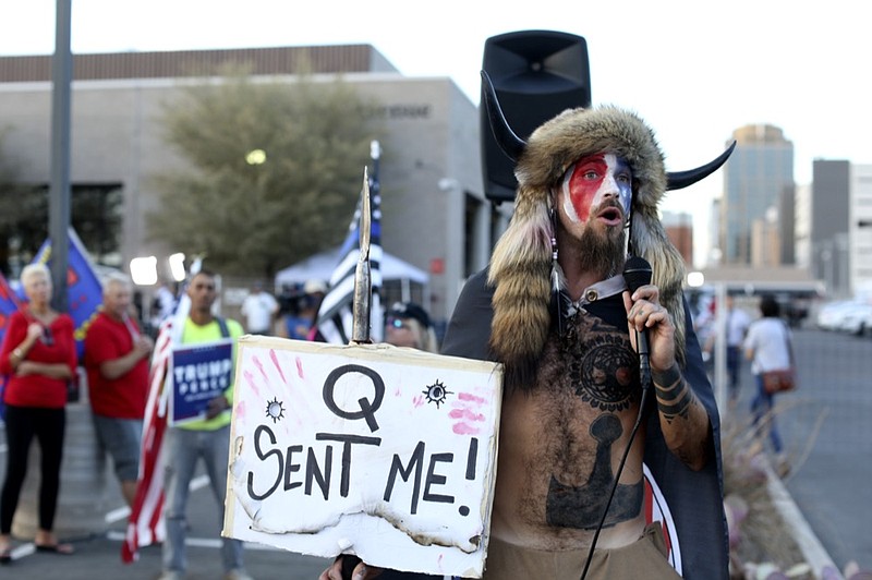 FILE - In this Nov. 5, 2020, file photo, Jacob Anthony Chansley, who also goes by the name Jake Angeli, a Qanon believer speaks to a crowd of President Donald Trump supporters outside of the Maricopa County Recorder's Office where votes in the general election are being counted, in Phoenix. Some followers of the QAnon conspiracy theory are now turning to online support groups and even therapy to help them move on, now that it's clear Trump's presidency is over. (AP Photo/Dario Lopez-Mills, File)


