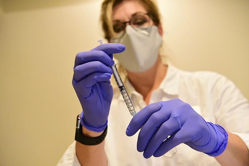 This Sept. 2020 photo provided by Johnson & Johnson shows a clinician preparing to administer investigational Janssen COVID-19 vaccine. Johnson & Johnson's long-awaited COVID-19 vaccine appears to protect against symptomatic illness with just one shot — not as strong as some two-shot rivals but still potentially helpful for a world in dire need of more doses. Johnson & Johnson said Friday, Jan. 29, 2021 that in the U.S. and seven other countries, the first single-shot vaccine appears 66% effective overall at preventing moderate to severe COVID-19. It was more protective against severe symptoms, 85%. (Johnson & Johnson via AP)