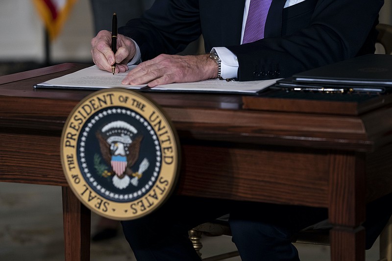 New York Times photo by Doug Mills/President Joe Biden signs a series of executive actions during a ceremony at the White House on Tuesday. More signings would follow throughout the week.