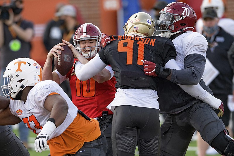 AP photo by Matthew Hinton / Alabama quarterback Mac Jones (10) gets tangled up with Florida State's Janarius Robinson (91) on Wednesday during an American Team practice for the Senior Bowl in Mobile, Ala.