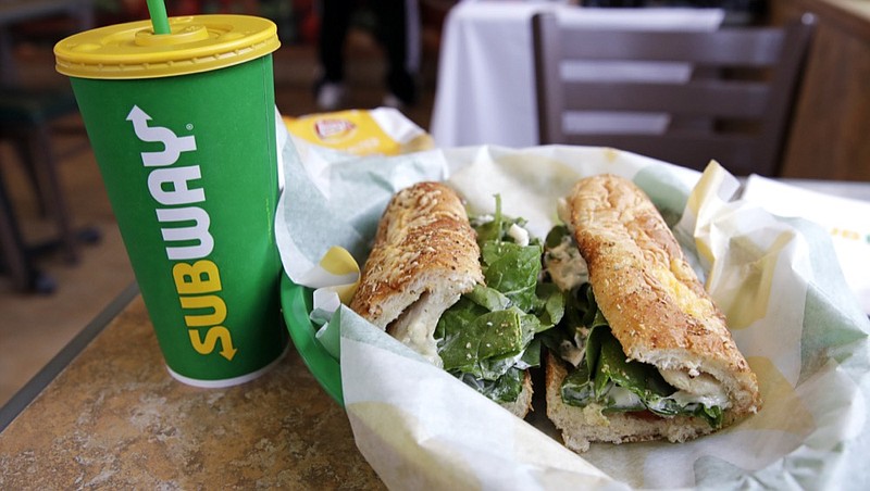 FILE - In this Friday, Feb. 23, 2018 file photo, the Subway logo is seen on a soft drink cup next to a sandwich at a restaurant in Londonderry, N.H. Ireland's Supreme Court ruled that bread sold by the fast food chain Subway contains so much sugar that it cannot be legally defined as bread. (AP Photo/Charles Krupa, File)


